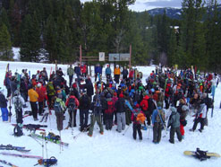Group of snowboarders/skiers gathered around instructors.